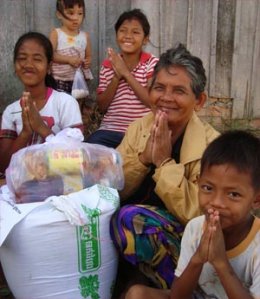 Grandmother and her grandchildren, grateful to get flooding relief in Cambodia.